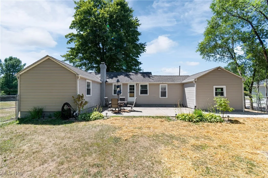 Rear view of house with a patio and a chimney