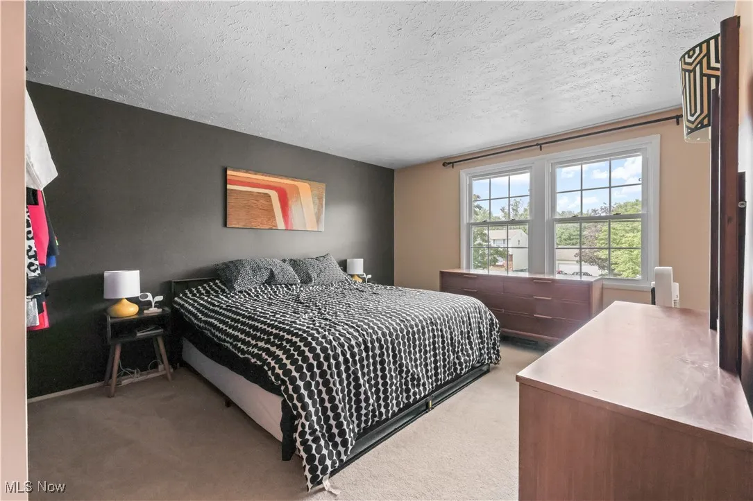 Bedroom with light carpet and a textured ceiling