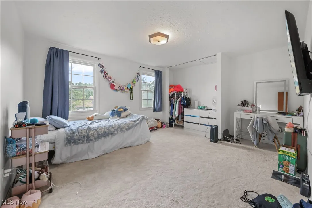 Bedroom featuring carpet and a textured ceiling
