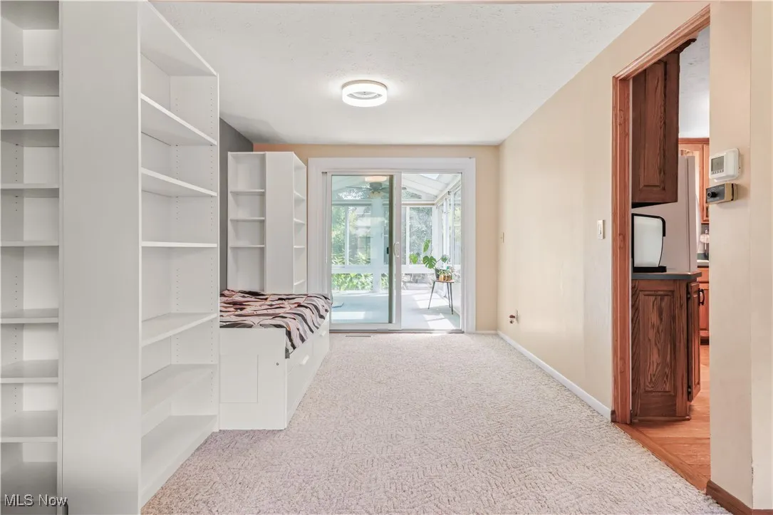 Mudroom featuring light colored carpet and a textured ceiling