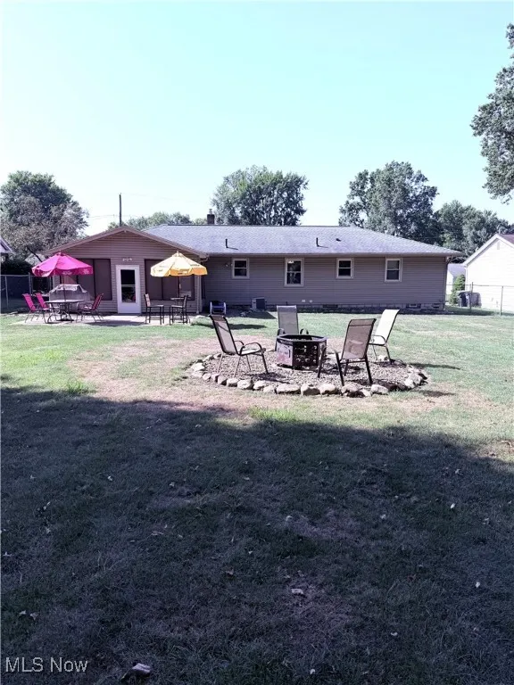 Rear view of house featuring an outdoor fire pit and a patio