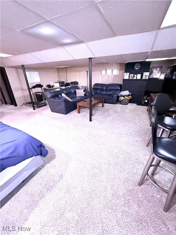 Carpeted living room featuring a drop ceiling