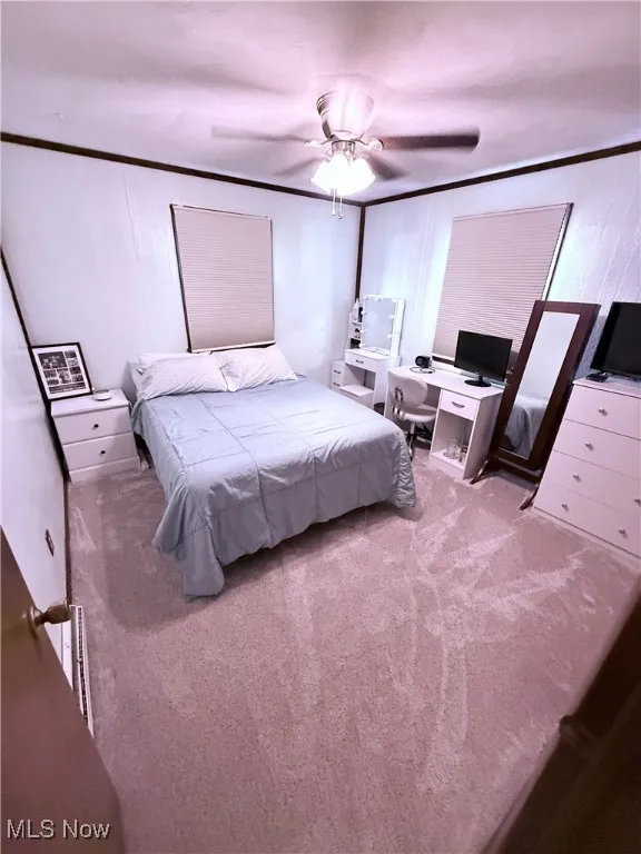 Bedroom with carpet floors, crown molding, and a desk