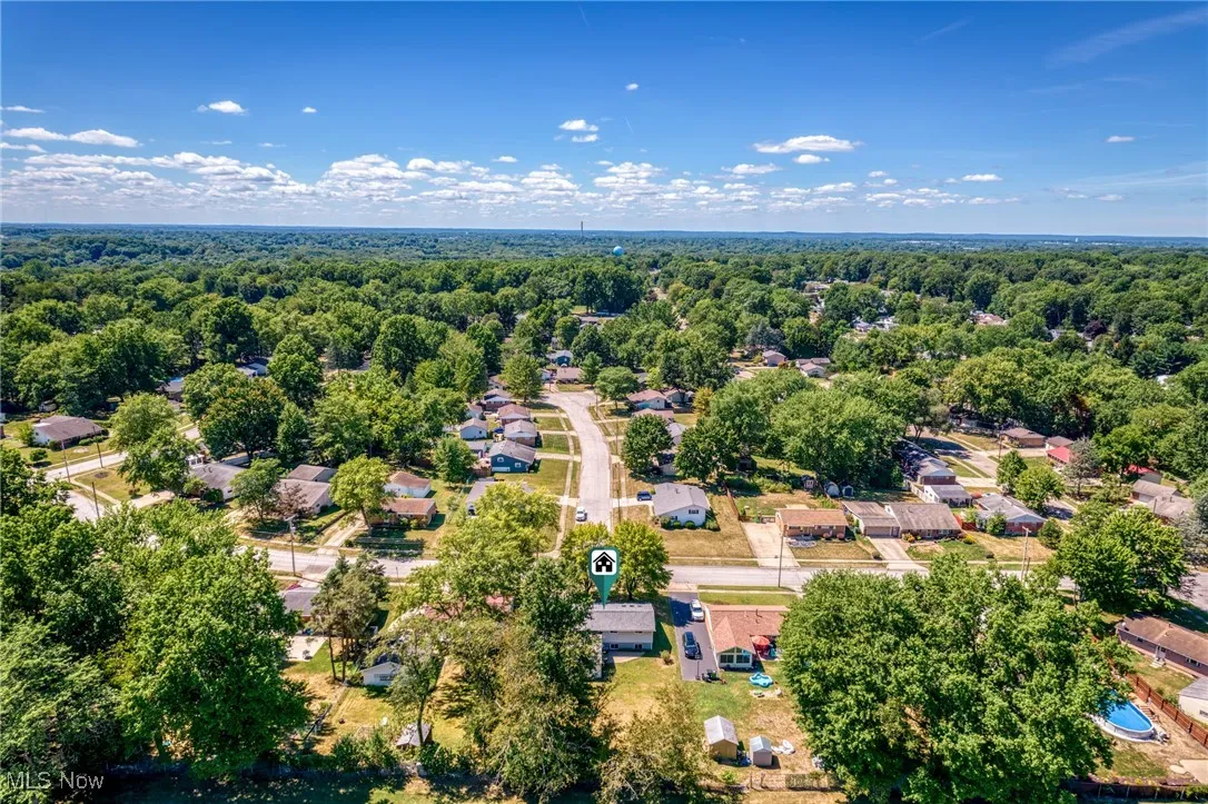 Aerial perspective of suburban area featuring a heavily wooded area
