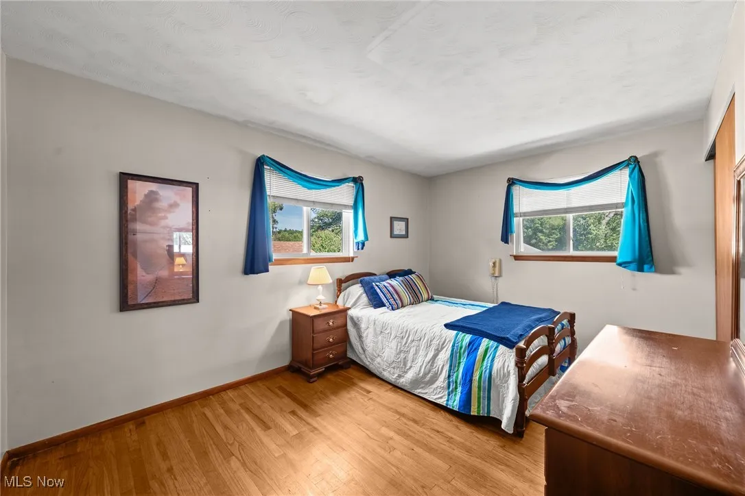 Bedroom with light wood-style floors and multiple windows