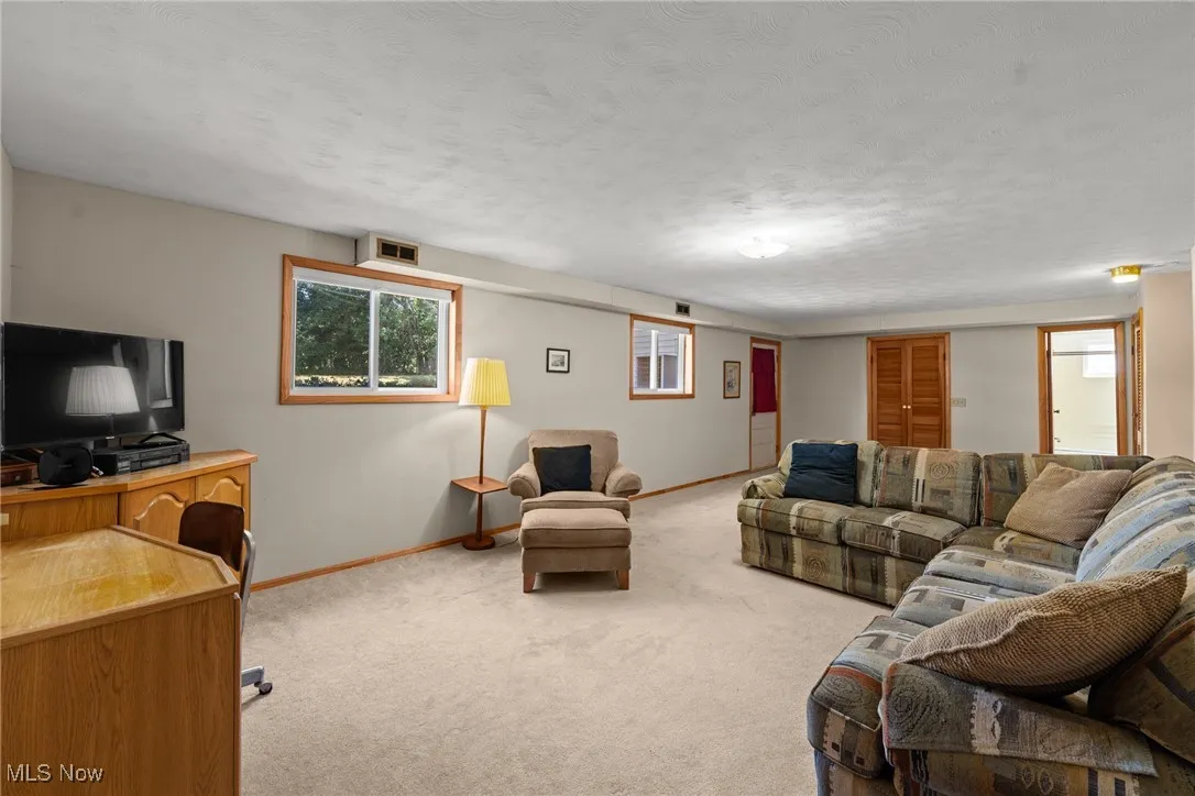 Carpeted living area with baseboards and a textured ceiling