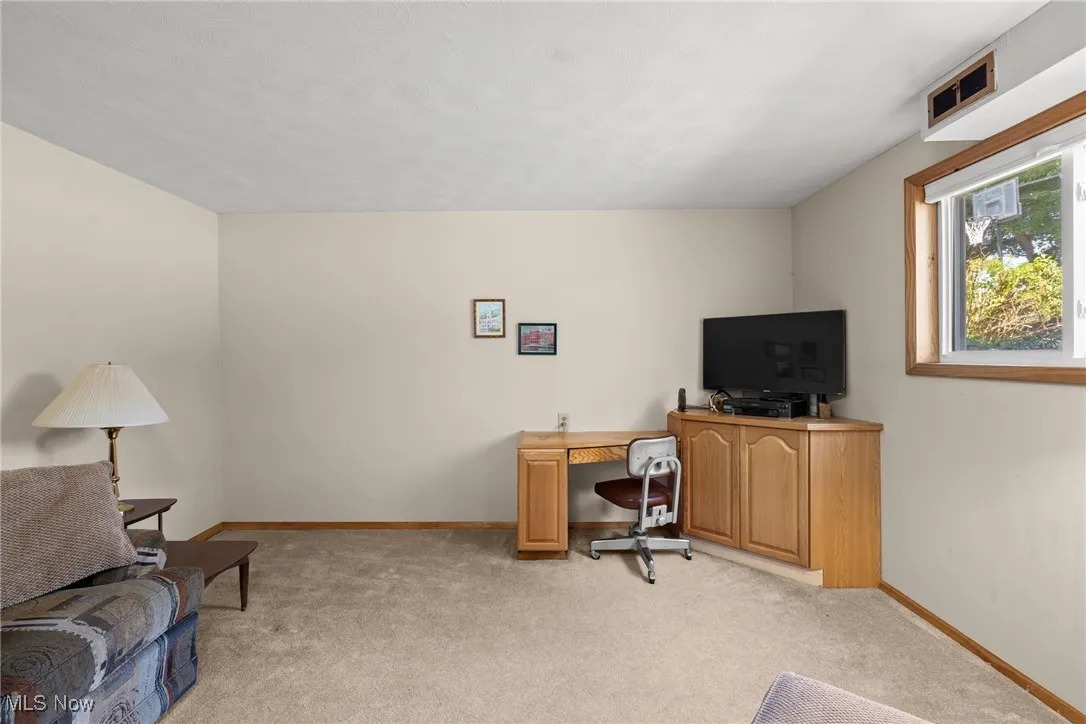 Office space with light carpet and baseboards