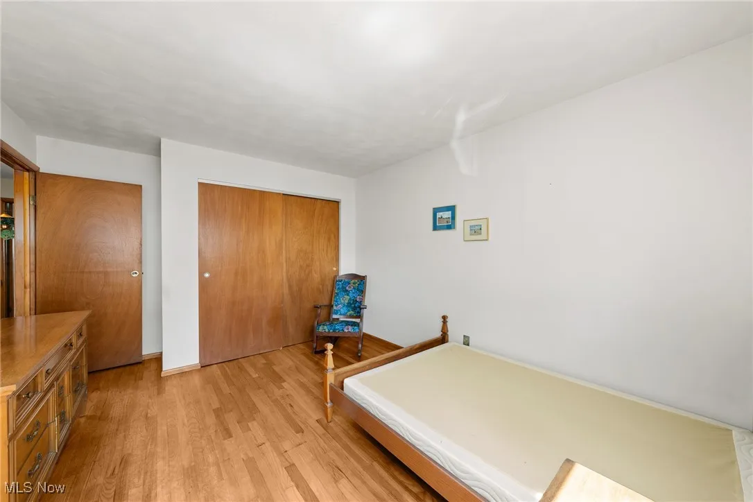 Bedroom featuring light wood finished floors and a closet