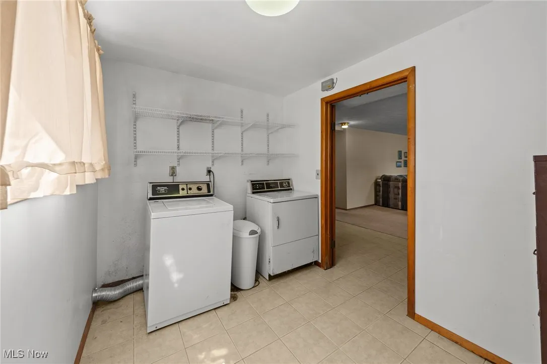 Laundry room with baseboards and washing machine and dryer