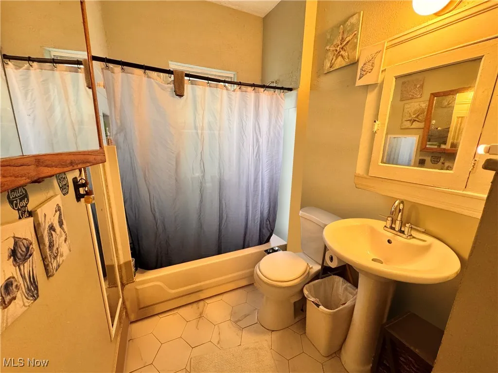 Unit 2 Bathroom featuring shower / tub combo, tile patterned flooring, and a textured wall