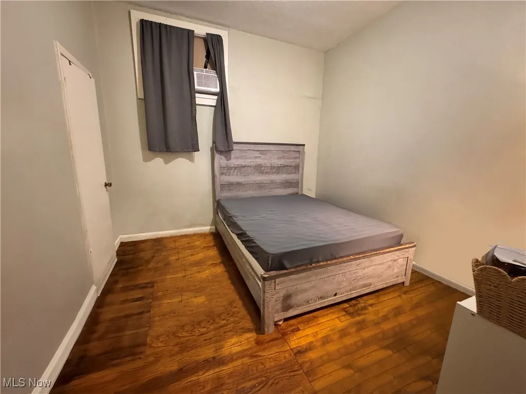 unit 1 Bedroom featuring baseboards and dark wood-type flooring