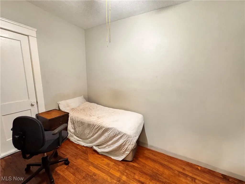 Unit 3 Bedroom featuring wood finished floors and a textured ceiling