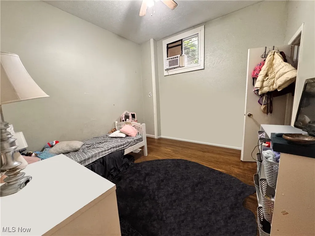 Unit 1 Bedroom with a textured ceiling, wood finished floors, and ceiling fan