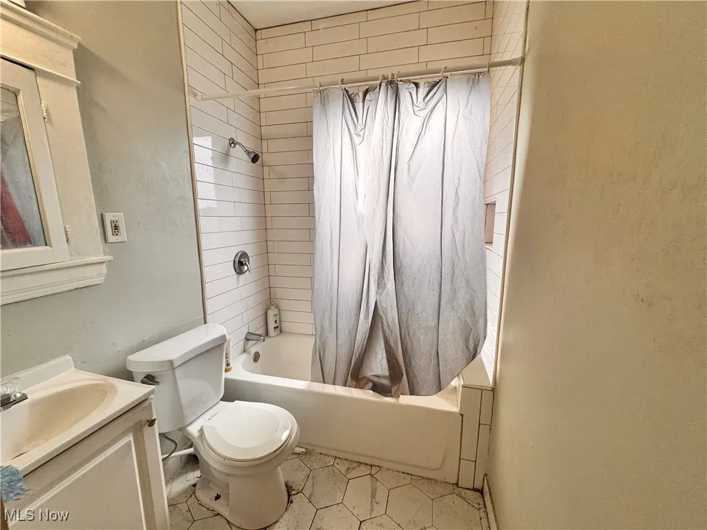 unit 4 Bathroom featuring shower / tub combo, vanity, and light tile patterned floors