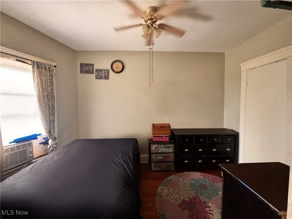 Unit 2 Bedroom with a textured ceiling, ceiling fan, wood finished floors, and cooling unit