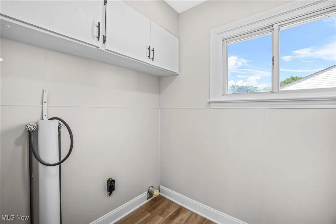 Washroom featuring light wood-type flooring and cabinet space