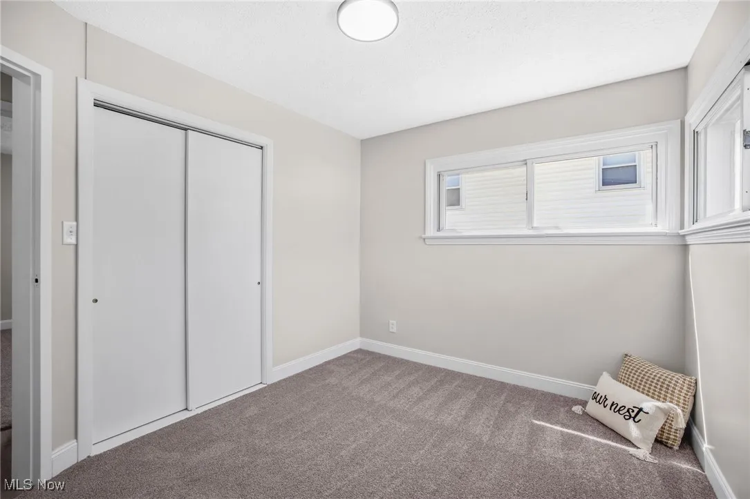 Unfurnished bedroom with carpet and a closet