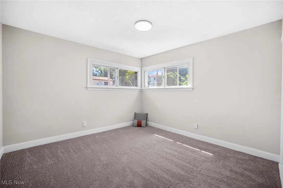 Empty room with carpet flooring and a textured ceiling