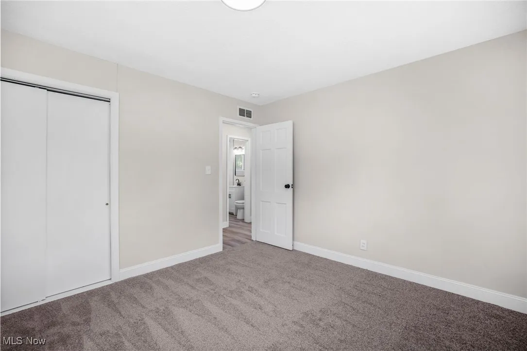Unfurnished bedroom featuring a closet and carpet floors