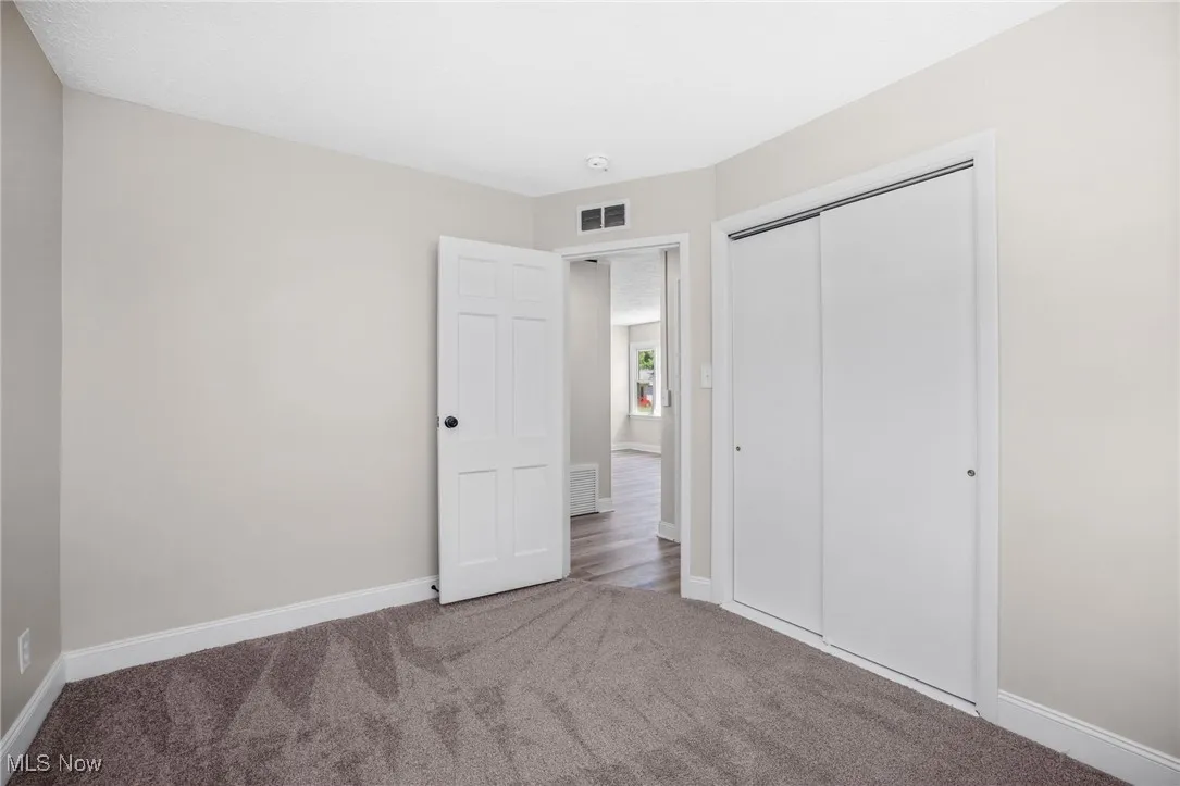 Unfurnished bedroom featuring carpet floors and a​​‌​​​​‌​​‌‌​‌‌​​​‌‌​‌​‌​‌​​​‌​​ closet