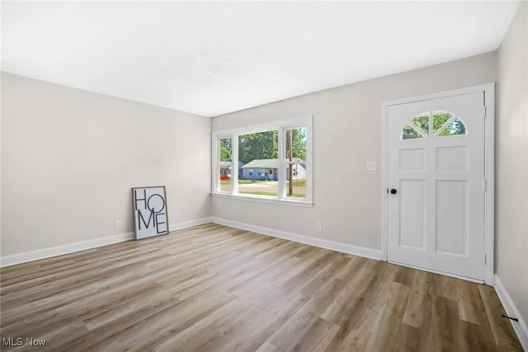 Foyer entrance with light wood-style flooring and a textured ceiling