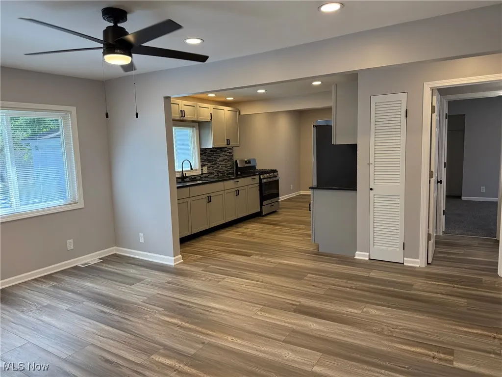 Kitchen with appliances with stainless steel finishes, recessed lighting, tasteful backsplash, a ceiling fan, and dark wood-style flooring