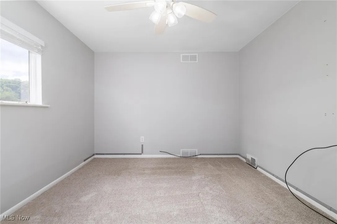 Primary Bedroom with new carpet, and ceiling fan
