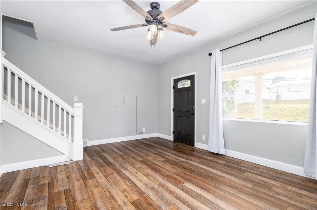 Front door entrance into living room with steps leading to the upstairs bedrooms