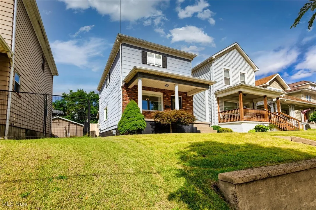 View of front of home with covered porch, a front yard