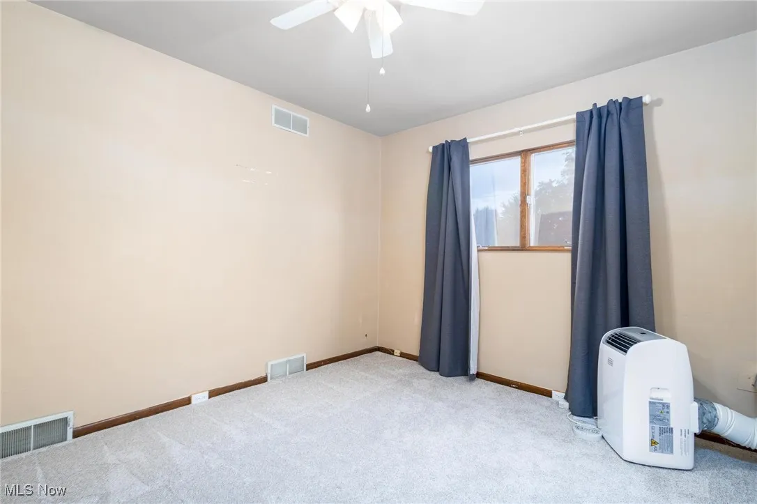 Bedroom 1 with new carpet with portable AC unit & ceiling fan
