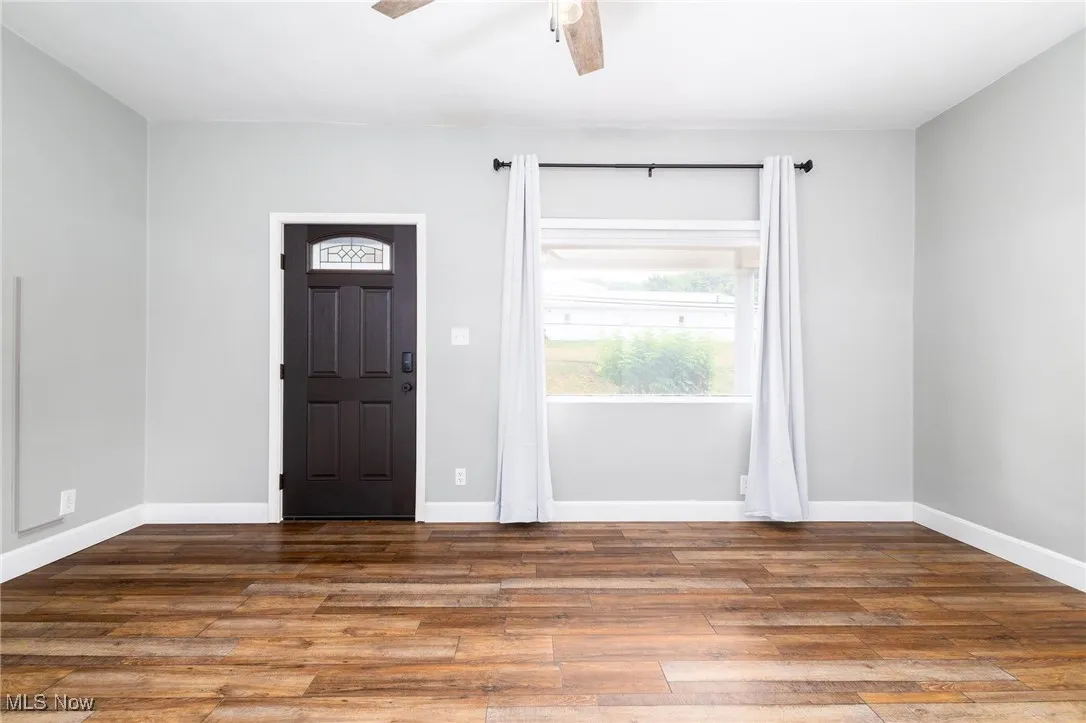 living room entrance featuring ceiling fan