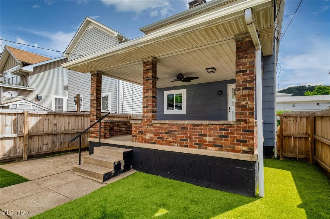 Fenced backyard featuring a ceiling fan and a patio area