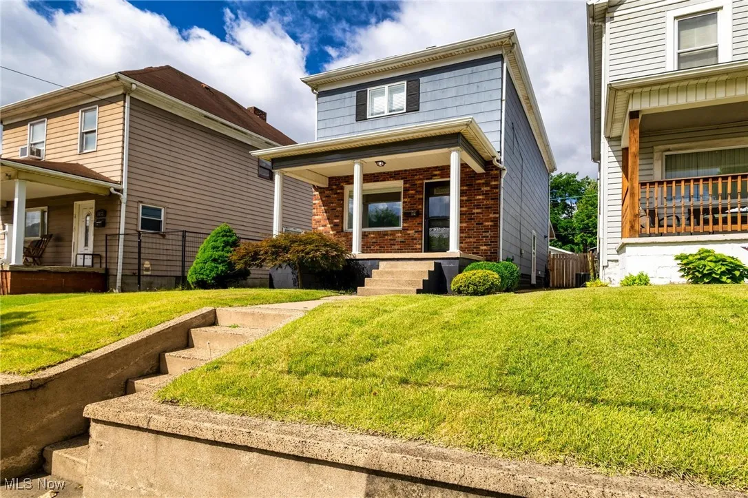 View of front of home with covered porch, and front lawn
