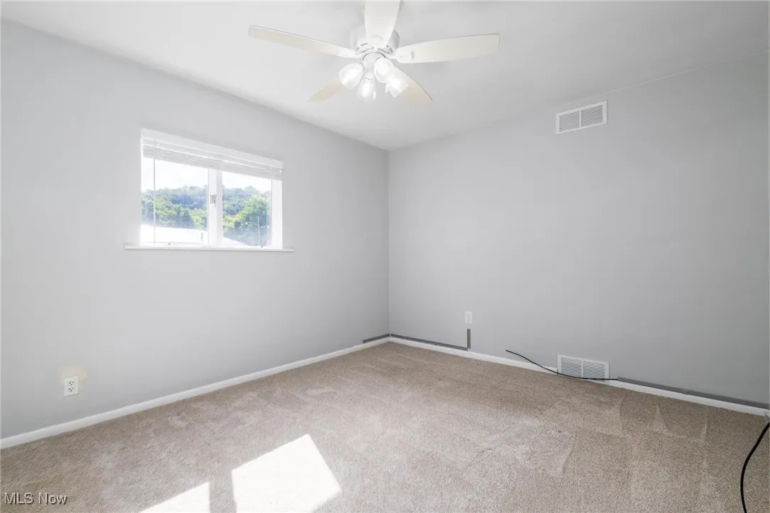 Primary Bedroom with new carpet and ceiling fan
