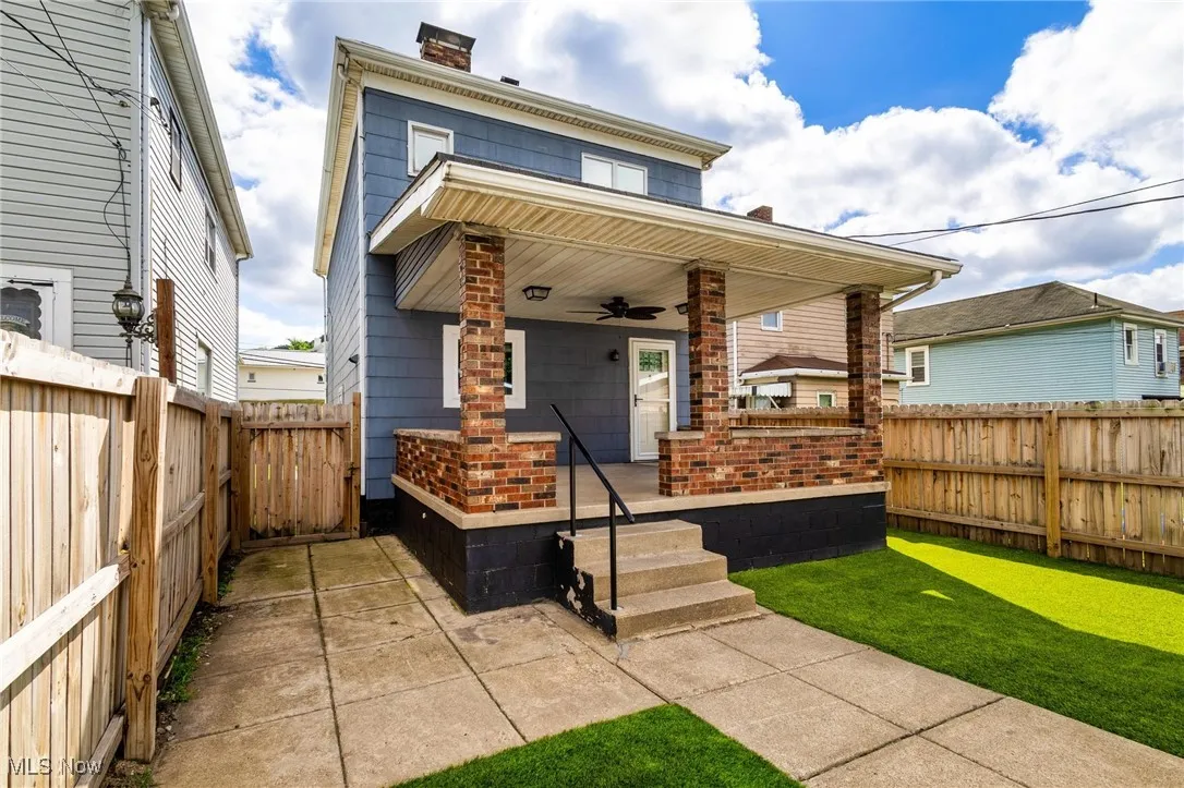 View of back of the home with a fenced backyard, patio and ceiling fan.