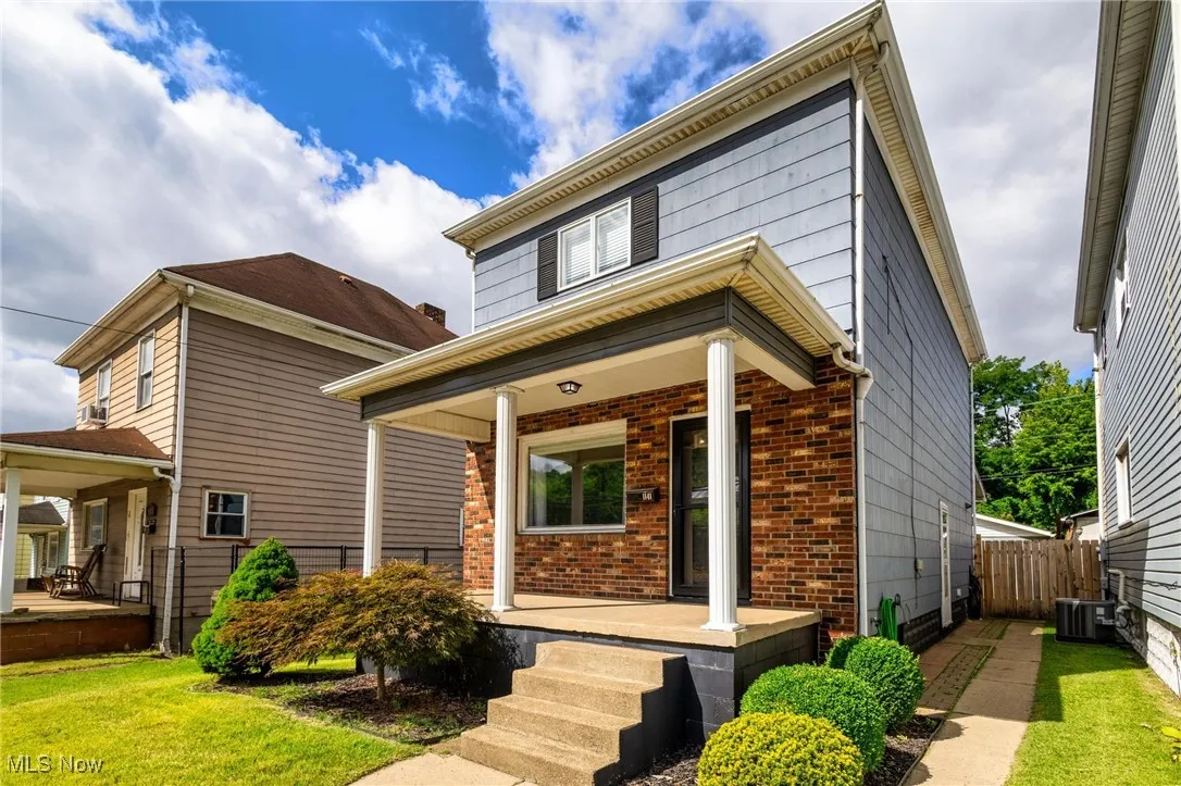 Traditional style home with covered porch and front yard