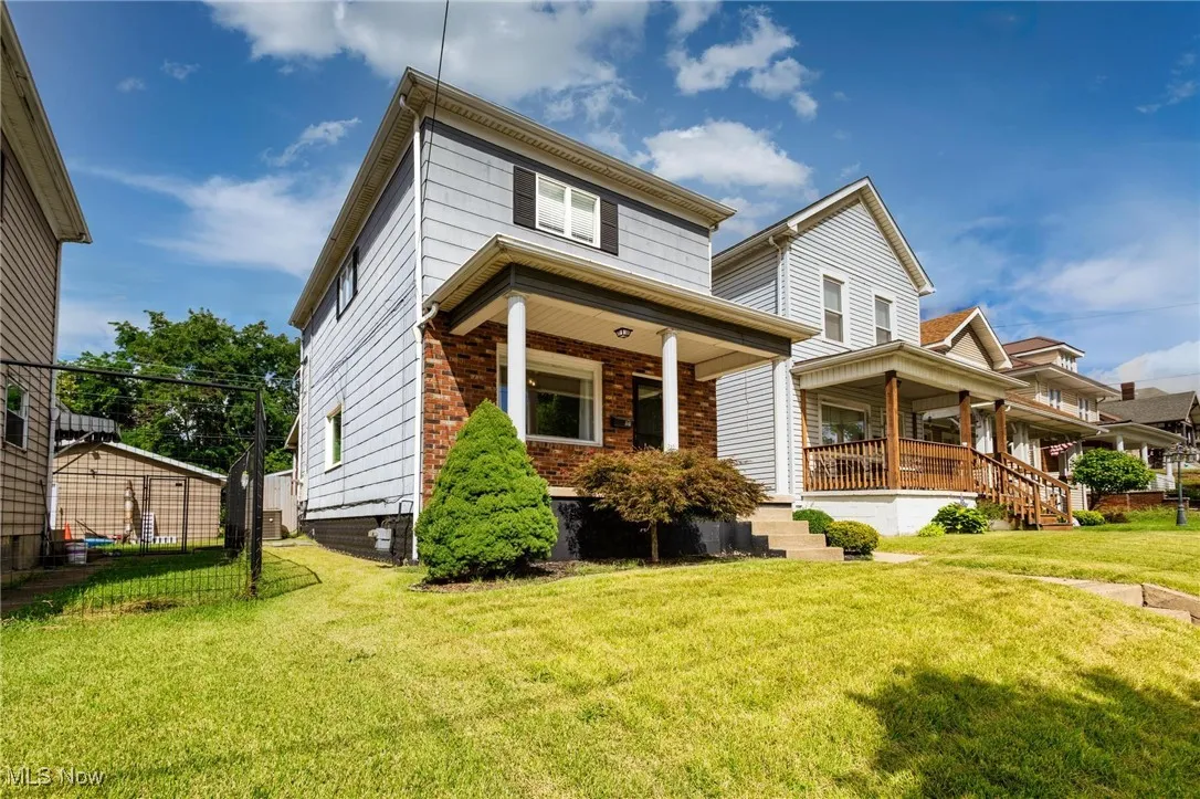 View of front of property featuring covered porch and a front yard