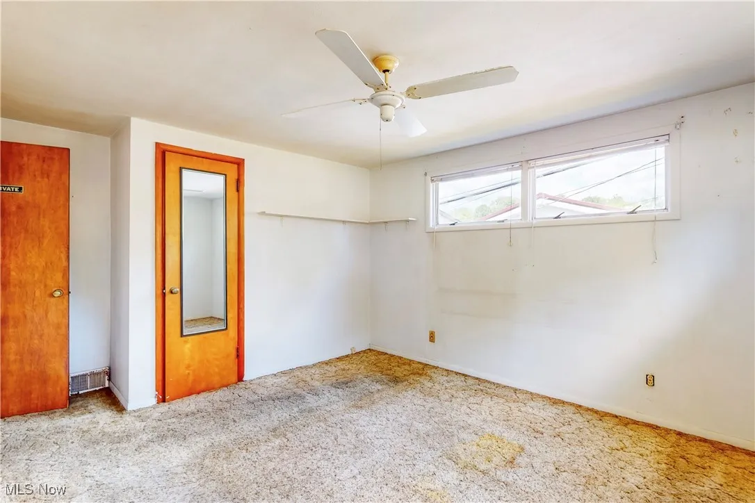 Spare room with carpet and ceiling fan