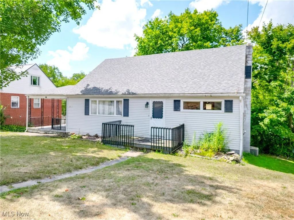 Rear view of property featuring a yard, a shingled roof, and a wooden deck