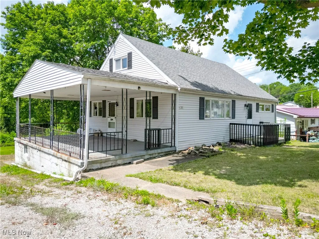 View of front of property featuring a shingled roof, a porch, and a front lawn