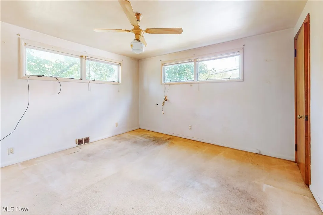 Unfurnished bedroom featuring light colored carpet and a ceiling fan