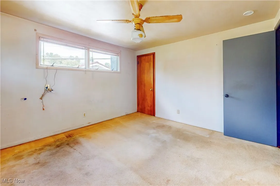 Unfurnished bedroom with carpet and a ceiling fan