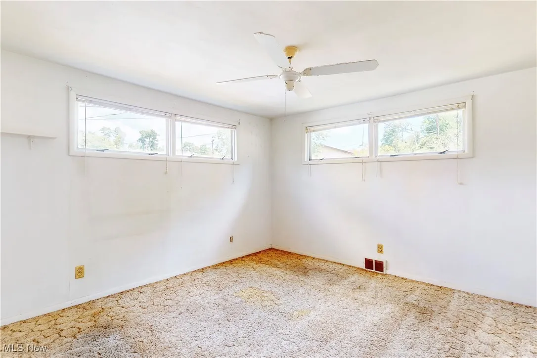 Unfurnished room with ceiling fan and carpet flooring