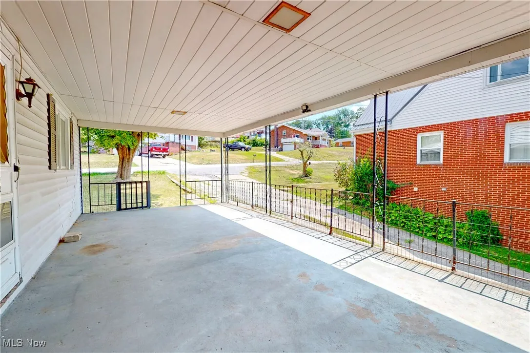 Covered porch featuring a residential view and a carport