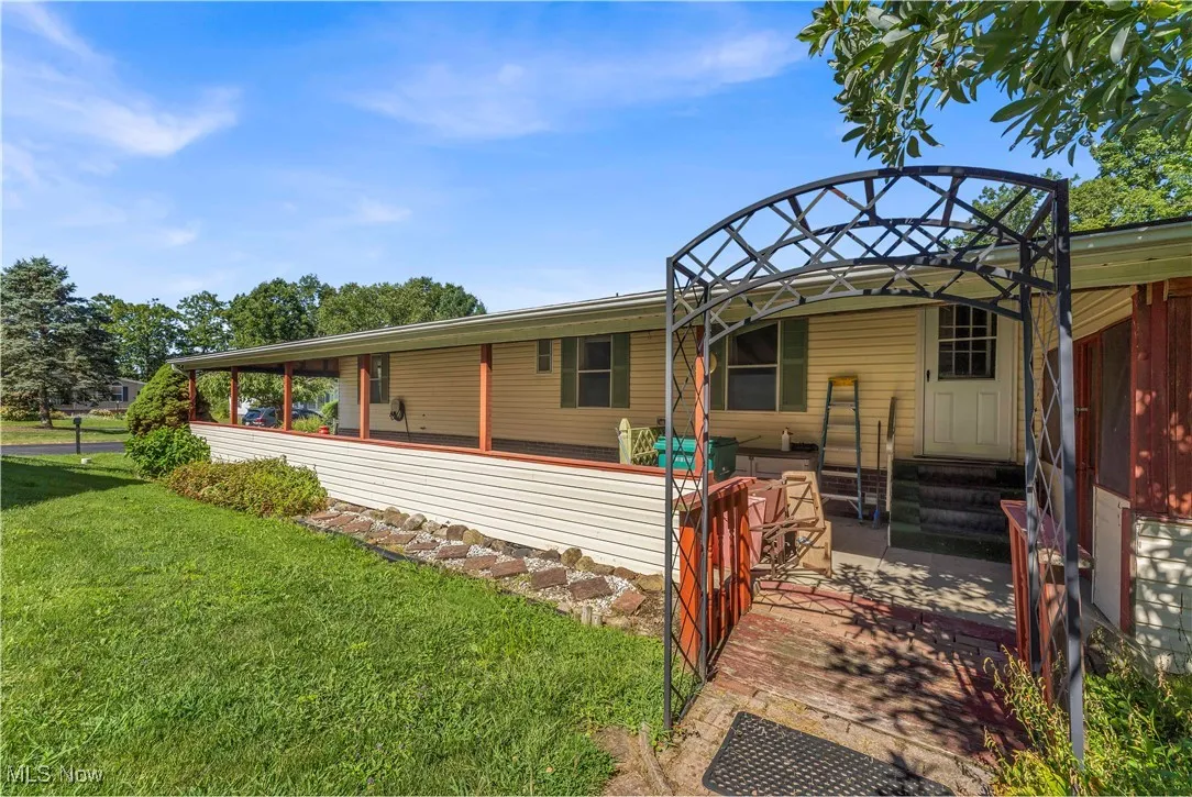 View of front of home featuring a front yard, a patio, and a​​‌​​​​‌​​‌‌​‌‌​​​‌‌​‌​‌​‌​​​‌​​ sunroom