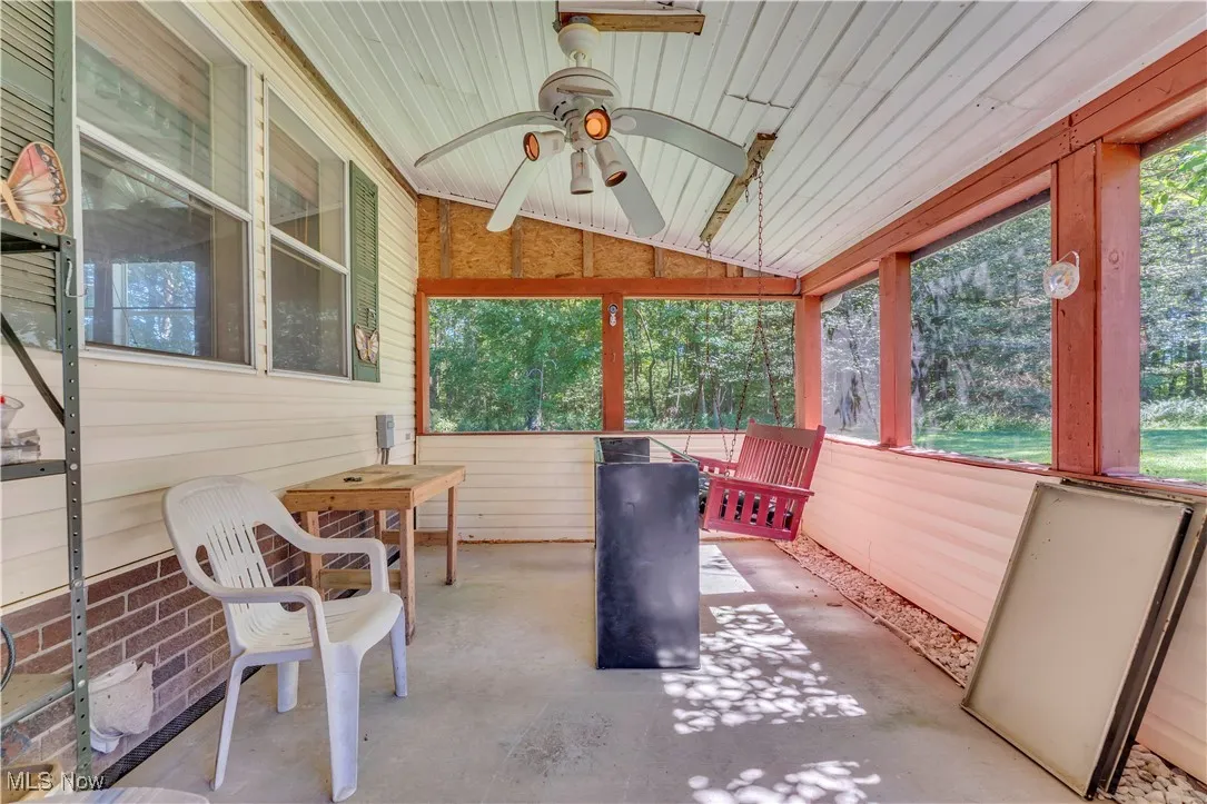 Sunroom / solarium with ceiling fan, plenty of natural light, and lofted ceiling