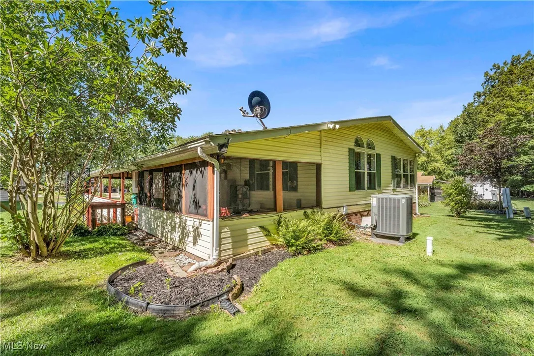 Back of house featuring a sunroom and a yard
