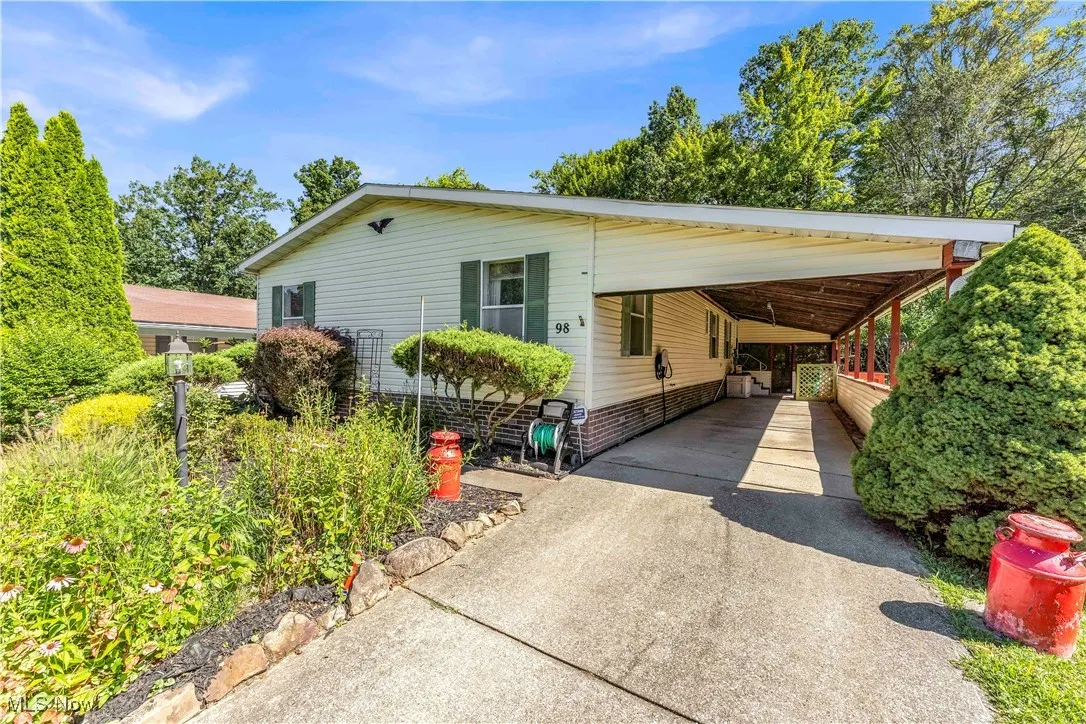 Manufactured / mobile home featuring driveway and an attached carport