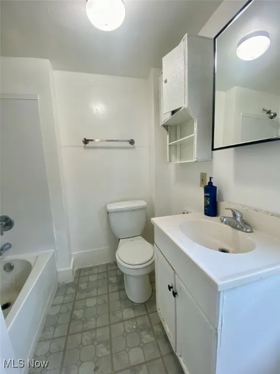 Bathroom featuring vanity, tile patterned floors, and shower / washtub combination