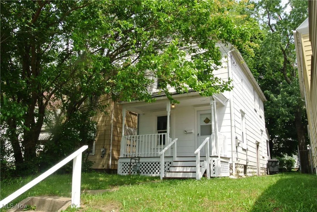 View of front of property with a porch and a front yard